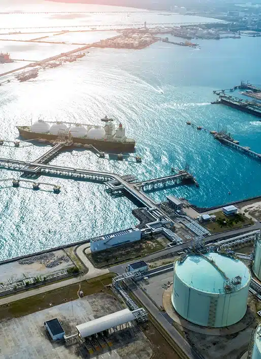 Aerial view of the ocean and large tank on land