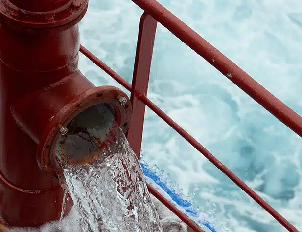 Water existing a valve with water in the background