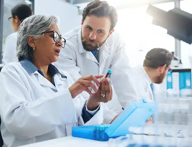 Une femme tient un récipient de prélèvement dans un laboratoire tandis qu'un homme l'observe