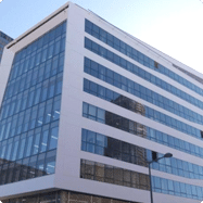 Immeuble de bureaux moderne, avec une façade en verre et une structure à plusieurs étages.