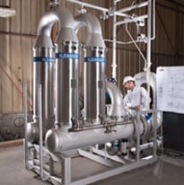 Système de filtration industrielle en acier inoxydable installé dans une usine de transformation.