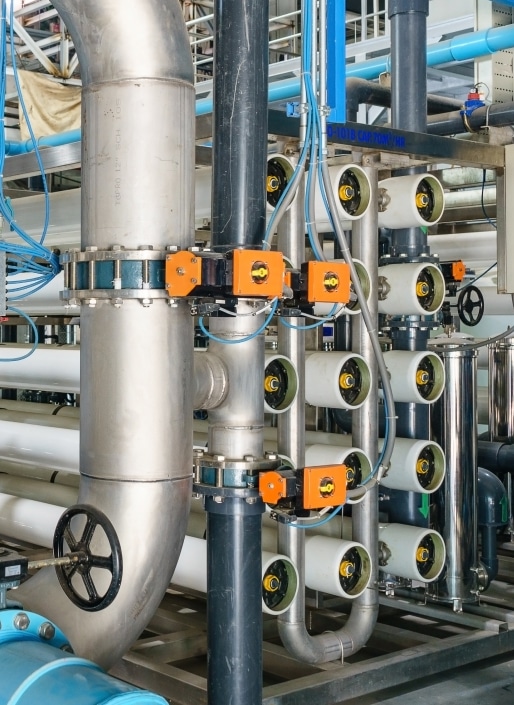 Système de filtration industrielle comprenant de gros tuyaux métalliques, des vannes de régulation et des filtres cylindriques.