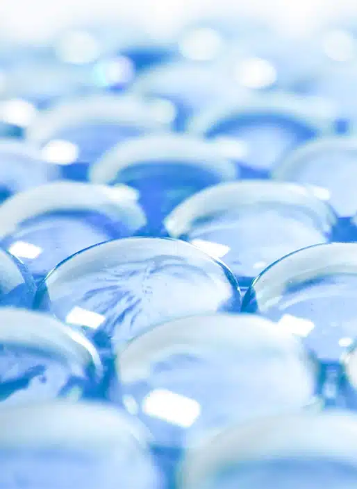 Abstract close-up of transparent glass spheres with soft blue reflections and futuristic aesthetic.