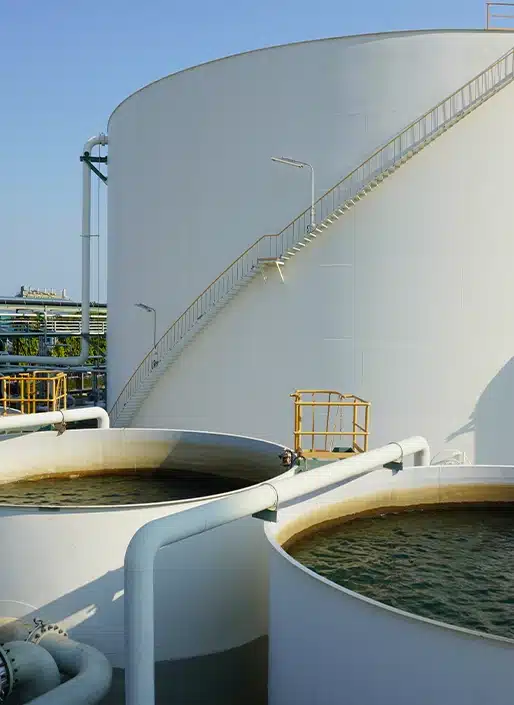 Trois grands réservoirs d'eau blancs, dont deux sont ouverts sur le dessus, laissant voir l'eau qu'ils contiennent