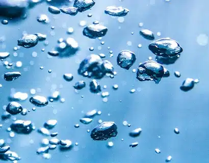 Des gouttelettes d'eau sur un fond bleu réfléchissant.