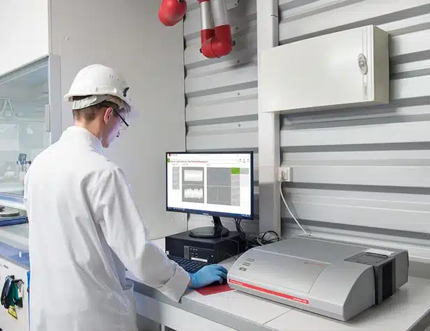 Un homme en blouse de laboratoire devant un ordinateur